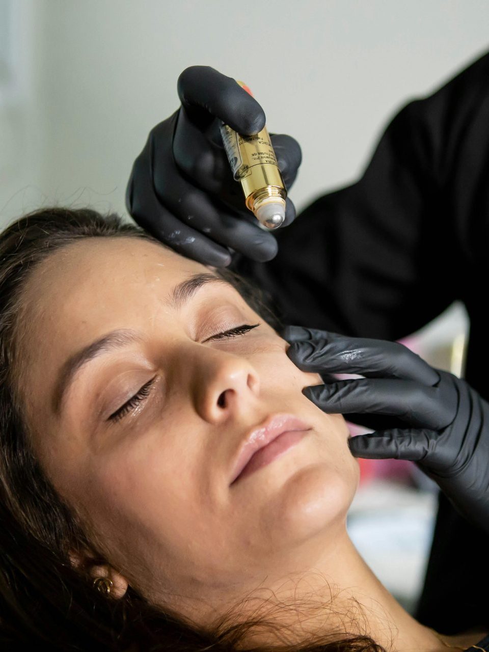 Close-up of a woman receiving a cosmetic skin care treatment in a clinic.